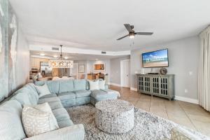 a living room with a blue couch and a tv at Caribe 306 C in Orange Beach
