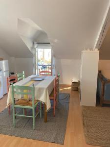 a dining room with a table and some chairs at Appartement Typlouz in Le Quiou