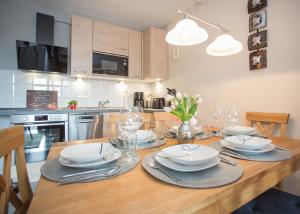 a kitchen with a wooden table with plates and glasses at Bike & Ski kappe, am Bikepark, Skilift in Winterberg