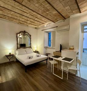 Un dormitorio con una cama grande y una mesa y sillas. en Suite Termini - Cozy suite few steps from Termini station, en Roma