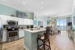 a kitchen with white cabinets and a dining room at Spanish Key 702 in Perdido Key