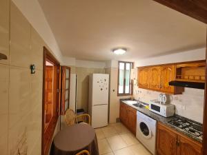 Una cocina con gabinetes de madera y un refrigerador blanco. en Gloria Apartament, en Puerto Naos