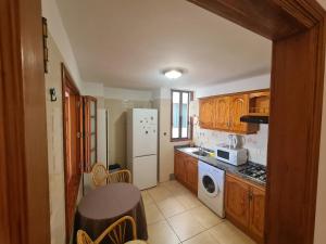 Una cocina con gabinetes de madera y un refrigerador blanco. en Gloria Apartament, en Puerto Naos 16 fotos más