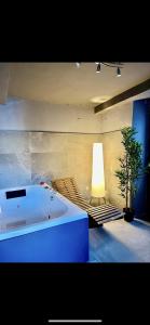 a room with a tub and a couch and a lamp at VILLA Como, Jacuzzi Spa and Private Pool in Blevio