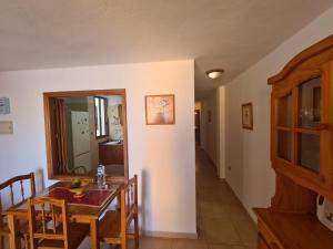 Una cocina y un comedor con mesa y sillas. en Gloria Apartament, en Puerto Naos