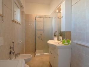 een badkamer met douche, wastafel en toilet bij Appartamenti Vittoria in Lido di Pomposa +12 foto's