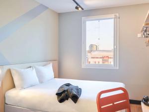 a bedroom with a bed with a hat on it at ibis budget Issy Les Moulineaux Paris Ouest in Issy-les-Moulineaux