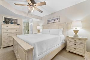 a bedroom with a white bed and a ceiling fan at Phoenix VII 907 in Orange Beach +27 photos