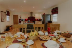 a table with plates and bowls of food on it at Sherrabeg Cottage in Laggan