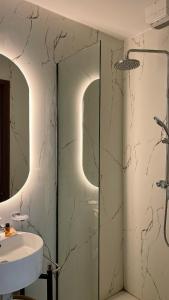 ein Badezimmer mit Glasdusche und Waschbecken in der Unterkunft Niche Boutique Hotel in Tirana