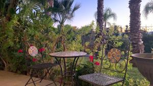 a table and chairs in a garden with palm trees at Il Giardino della Torre in Torre Maggiore
