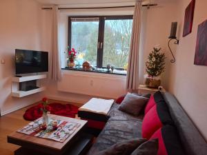 a living room with a couch and a window at Ferienwohnung Haus Schöneck in Schönecken
