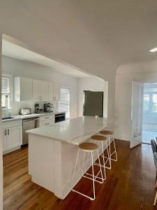 a kitchen with a white island with stools at Courthouse Corner - Beautiful adobe, pet friendly in Marfa