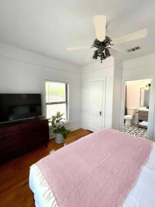 a bedroom with a bed and a flat screen tv at Courthouse Corner - Beautiful adobe, pet friendly in Marfa