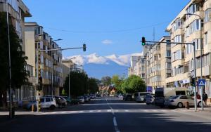a city street with buildings and mountains in the background at MODERN Apartament in Făgăraş