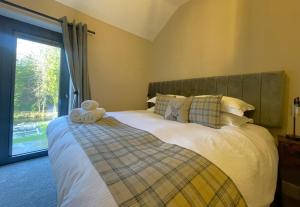 a teddy bear sitting on a bed in a bedroom at Greta House in Keswick