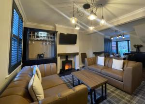 a living room with a couch and a fireplace at Greta House in Keswick