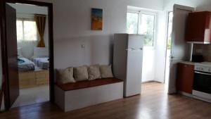 a kitchen with a refrigerator and a bedroom with a bed at Plakia Beach Apartments in Pefki