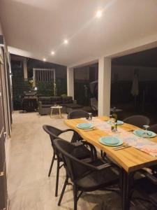 a wooden table and chairs in a living room at By the sea in Nea Potidaea