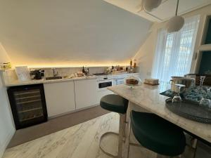 una cucina con mobili bianchi e un piano di lavoro di MAISON LADY CLAUDIA LUXURY ACCOMMODATION a Sorrento Altre 34 foto