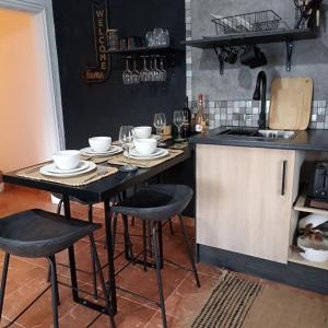 eine Küche mit einem Tisch mit Stühlen und Gläsern darauf in der Unterkunft Bougainvillea House in Ponta do Pargo