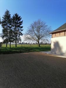 aphalt road with trees and a building and a field at Le loft d'Adrien, une ode à la douc'Eure, classé 3 étoiles, accueil vélo in Beauficel-en-Lyons
