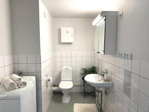 a white bathroom with a toilet and a sink at 3BR w balconies and private sauna in Helsinki +9 photos