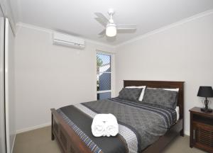 a bedroom with a bed and a ceiling fan at Capricorn Villas in Middlemount