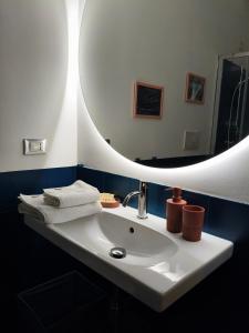 un bagno con un lavandino bianco e uno specchio di Fluère - Via Riva Reno a Bologna Altre 37 foto