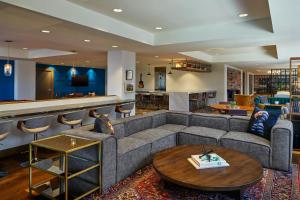 a living room with a couch and a bar at Renaissance Saint Elm Dallas Downtown Hotel in Dallas