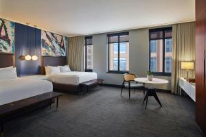a hotel room with two beds and a table at Renaissance Saint Elm Dallas Downtown Hotel in Dallas +52 photos
