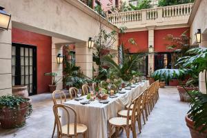 a long table in a courtyard with plants at Hotel Per La, Autograph Collection in Los Angeles