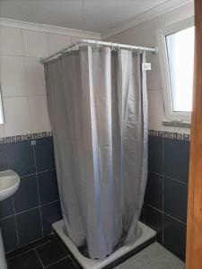 a shower curtain in a bathroom with a window at Casas Sao Sebastiao in Évora