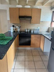 a kitchen with wooden cabinets and a black stove at The palace in Sandton