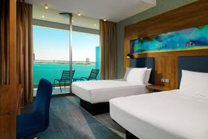 une chambre d'hôtel avec deux lits et une fenêtre dans l'établissement Aloft Palm Jumeirah, à Dubaï 37 autres photos