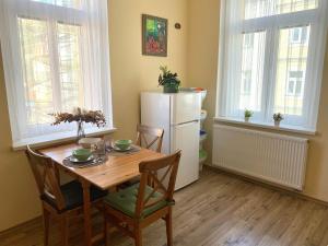 a kitchen with a table and chairs and a refrigerator at RomanceArt Apartments in Karlovy Vary