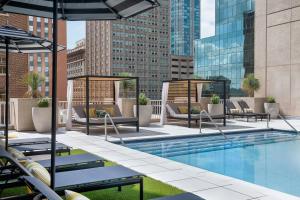a pool with chairs and umbrellas on a building at Le Meridien Fort Worth Downtown in Fort Worth