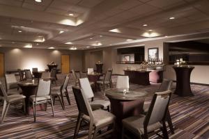 a restaurant with tables and chairs and a bar at Sheraton Bucks County Langhorne in Langhorne