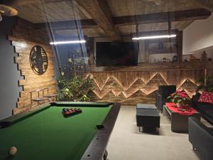 Habitación con mesa de billar y TV. en Muzyczny Dworek, en Rzepiska