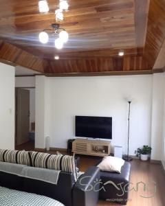 ein Wohnzimmer mit Couch und Flachbildfernseher in der Unterkunft Sanjang Guest House in Baguio City