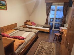 Un dormitorio con dos camas y una ventana. en Muzyczny Dworek, en Rzepiska