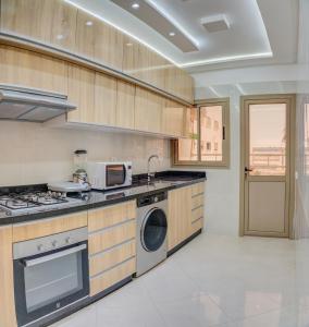 アガディールにあるTimitar, cozy one bedroom apartmentのキッチン(コンロ、洗濯機、乾燥機付)