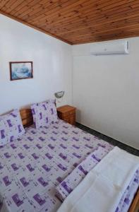 Un dormitorio con una cama y un techo de madera. en Family Hotel Magnolia - Summer residence, en Primorsko 18 fotos más