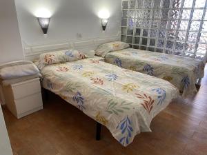 two twin beds in a room with a window at Estudio luminoso, primera línea de playa de las canteras in Las Palmas de Gran Canaria
