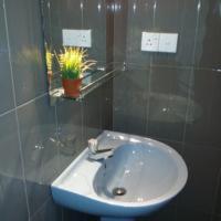 a bathroom with a white sink and a mirror at Villa Paragon in Negombo