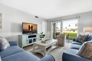 a living room with blue couches and a tv at El Matador 513 in Fort Walton Beach