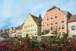 un groupe de bâtiments dans une ville fleurie dans l'établissement WAGNERS Hotel Greifen-Post, à Feuchtwangen