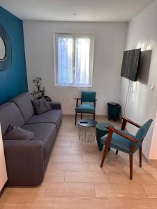 a living room with a couch and chairs and a tv at La petite maison des gîtes de Joséphine in Saint-Dyé-sur-Loire
