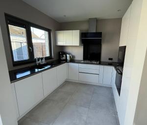 Una cocina vacía con gabinetes blancos y una ventana. en The Elegant Escape, en Malinas 3 fotos más