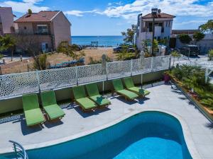 a swimming pool with chairs and the ocean in the background at Lafeyra Hotel in Limenaria